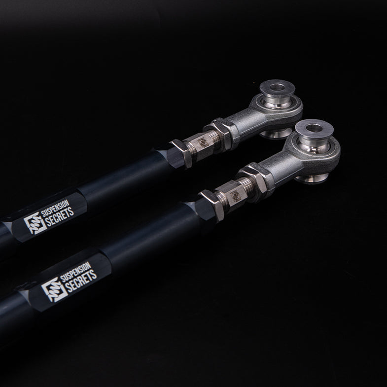 Suspension Secrets adjustable rear toe arms for BMW G87 M2, close-up of high-performance suspension linkage with brand logo.