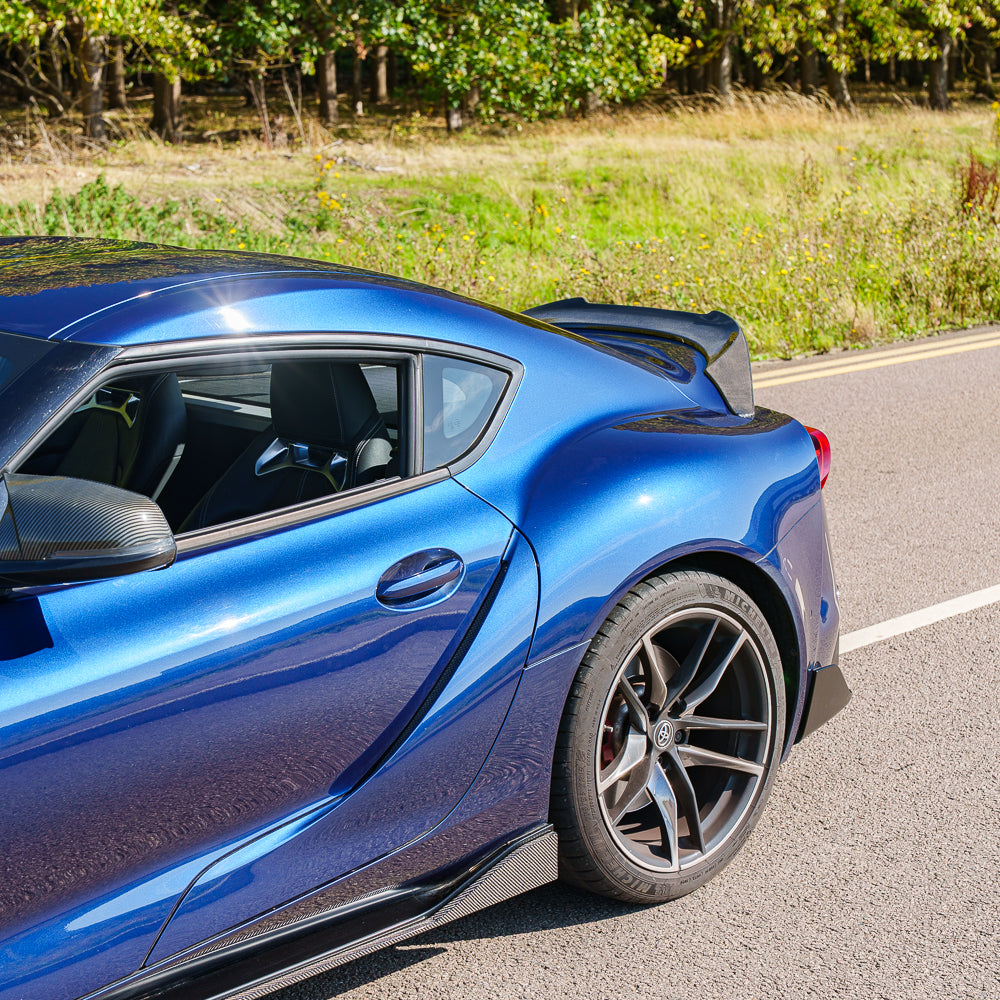 Carbon fiber side skirts for Toyota Supra 2019+ A90 by CT Carbon, showing sleek, aerodynamic design on the car.