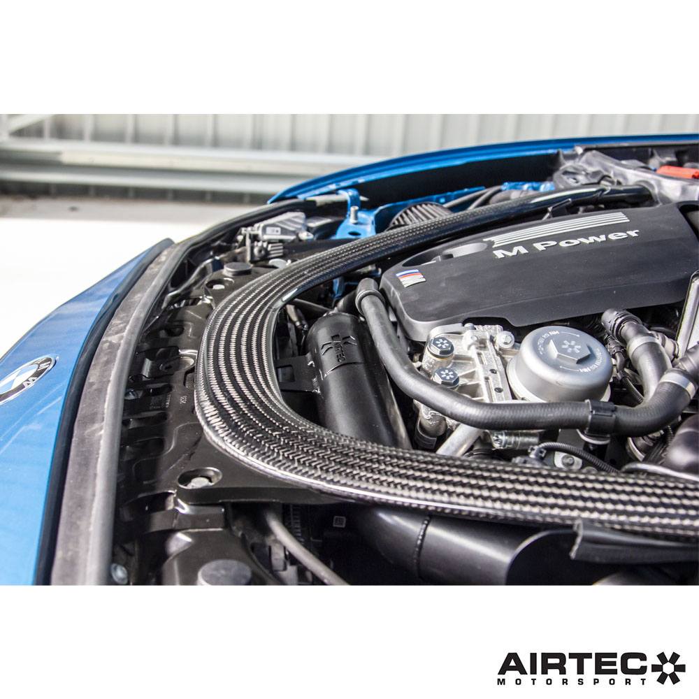 Airtec Motorsport induction kit installed in a BMW M3, showing the sleek air intake components and branding details.
