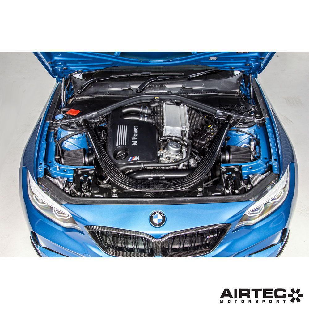 Airtec Motorsport induction kit installed in a BMW M2 Competition, M3, and M4, showcasing the high-performance air intake system.