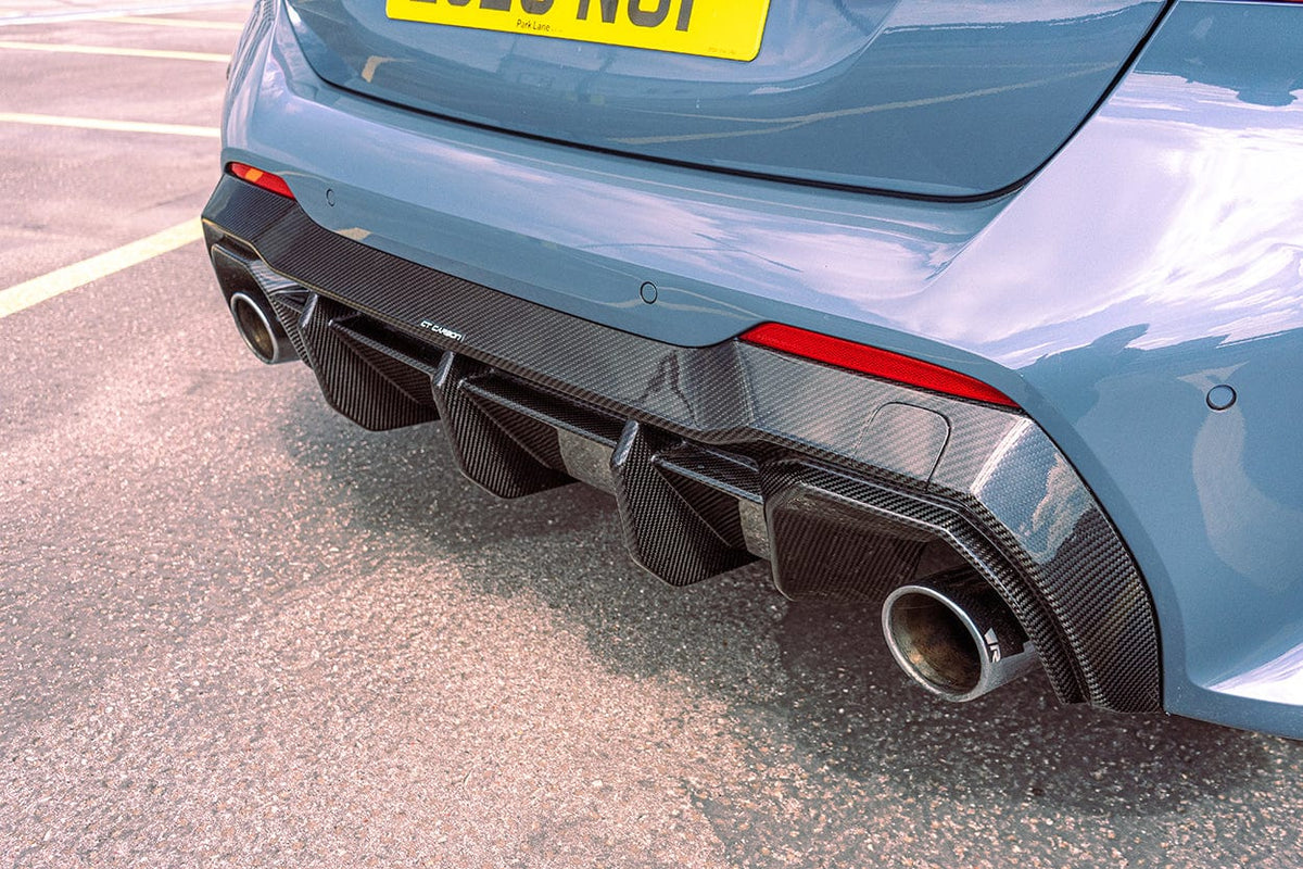 BMW 1 Series F40 carbon fiber diffuser by CT Design, showcasing sleek aerodynamic design and textured carbon fiber surface.