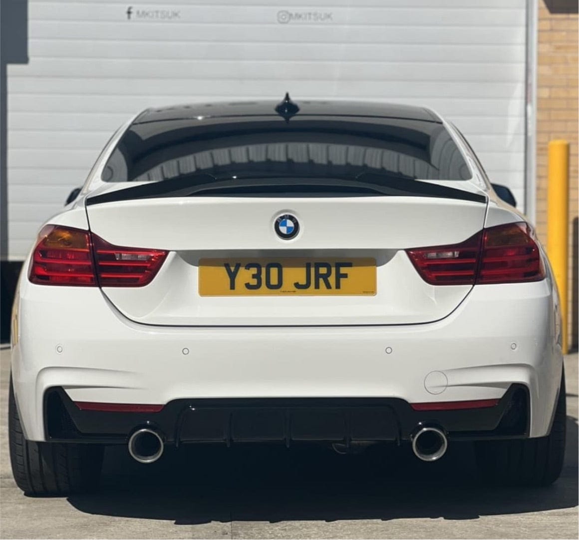 BMW 4 Series Gran Coupe F36 CT Carbon gloss black M-style spoiler on the car's rear, enhancing sporty appearance.
