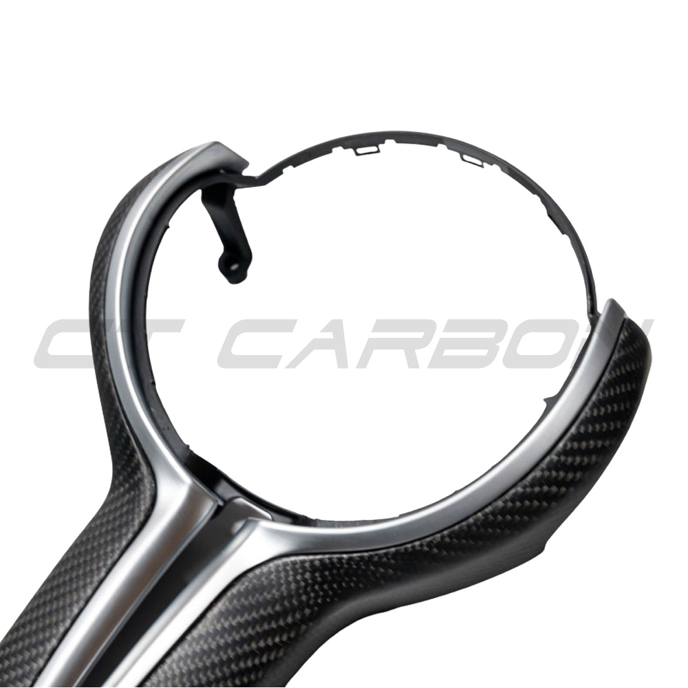 BMW Fxx M matte carbon fiber steering wheel trim by CT Carbon, close-up of sleek, textured carbon fiber accessory for car interior.