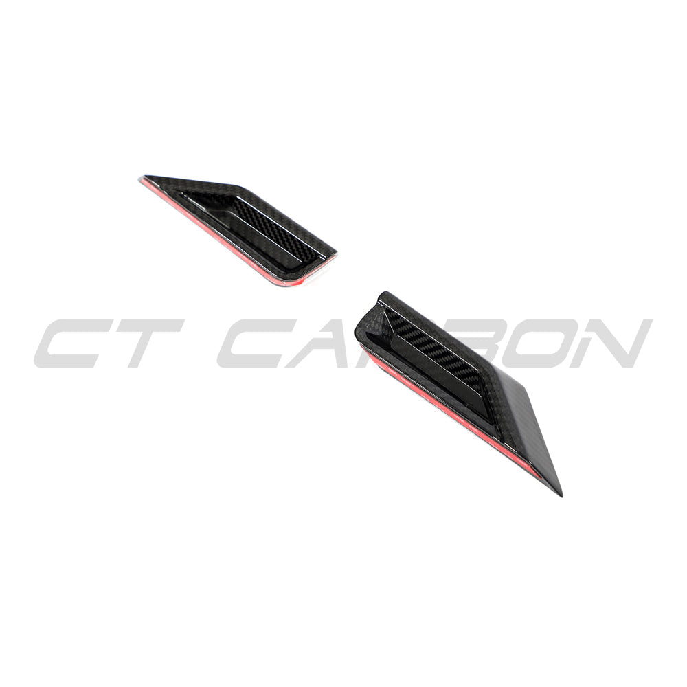 BMW G87 M2 carbon fiber front headlight add-on accessory by CT Carbon, showcasing sleek carbon fiber design on the vehicle.