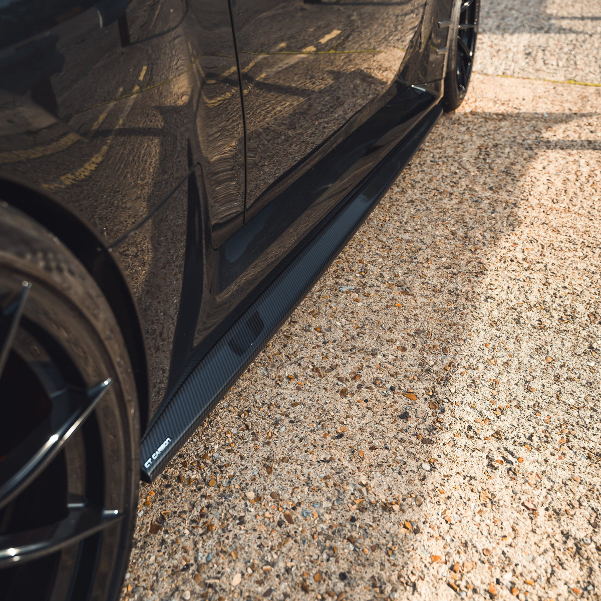 BMW G87 M2 carbon fiber side skirts by CT Design, showcasing sleek, lightweight aerodynamic enhancements on the car's sides.