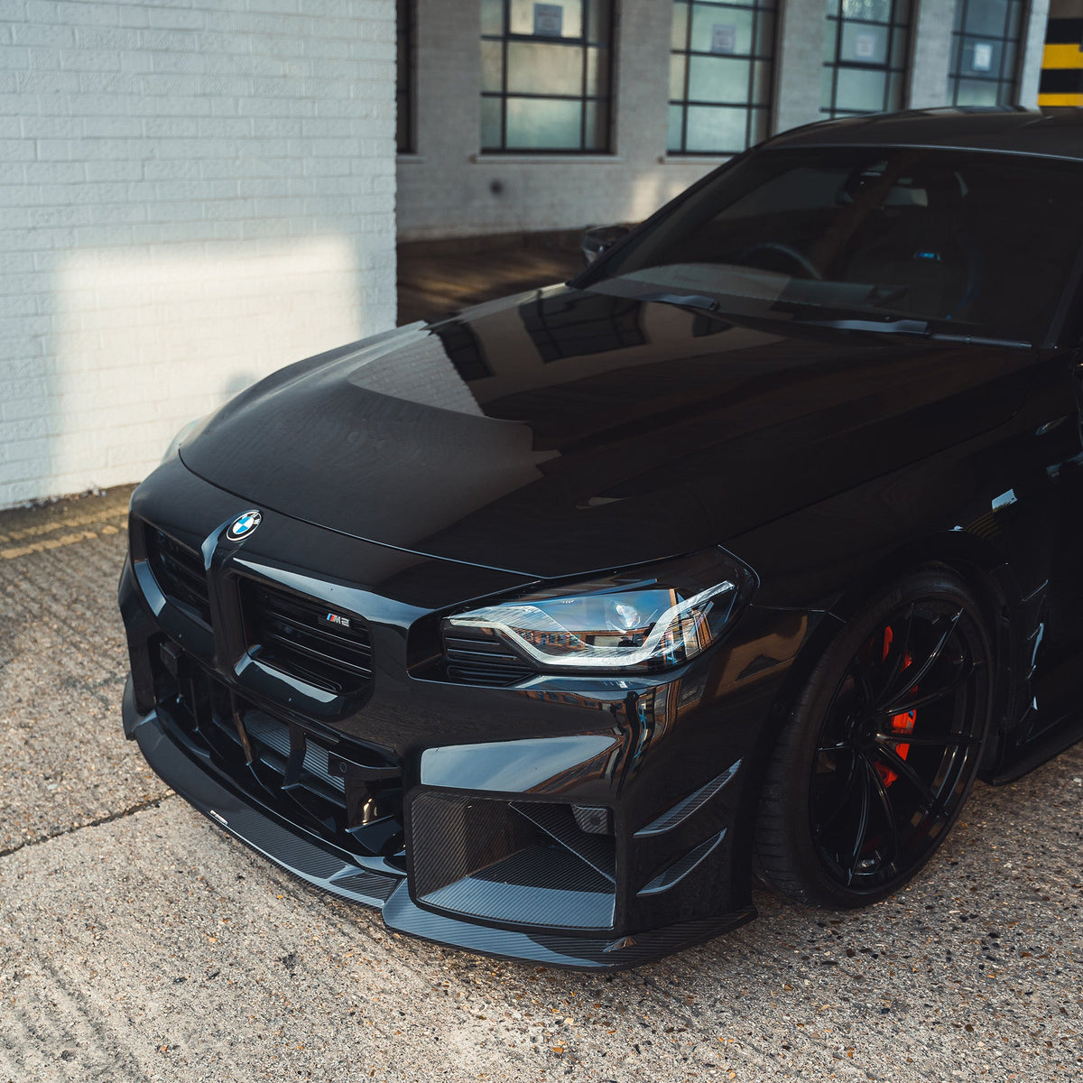 BMW G87 M2 carbon fiber splitter by CT Design, showing the sleek, lightweight aerodynamic front splitter in close-up view.