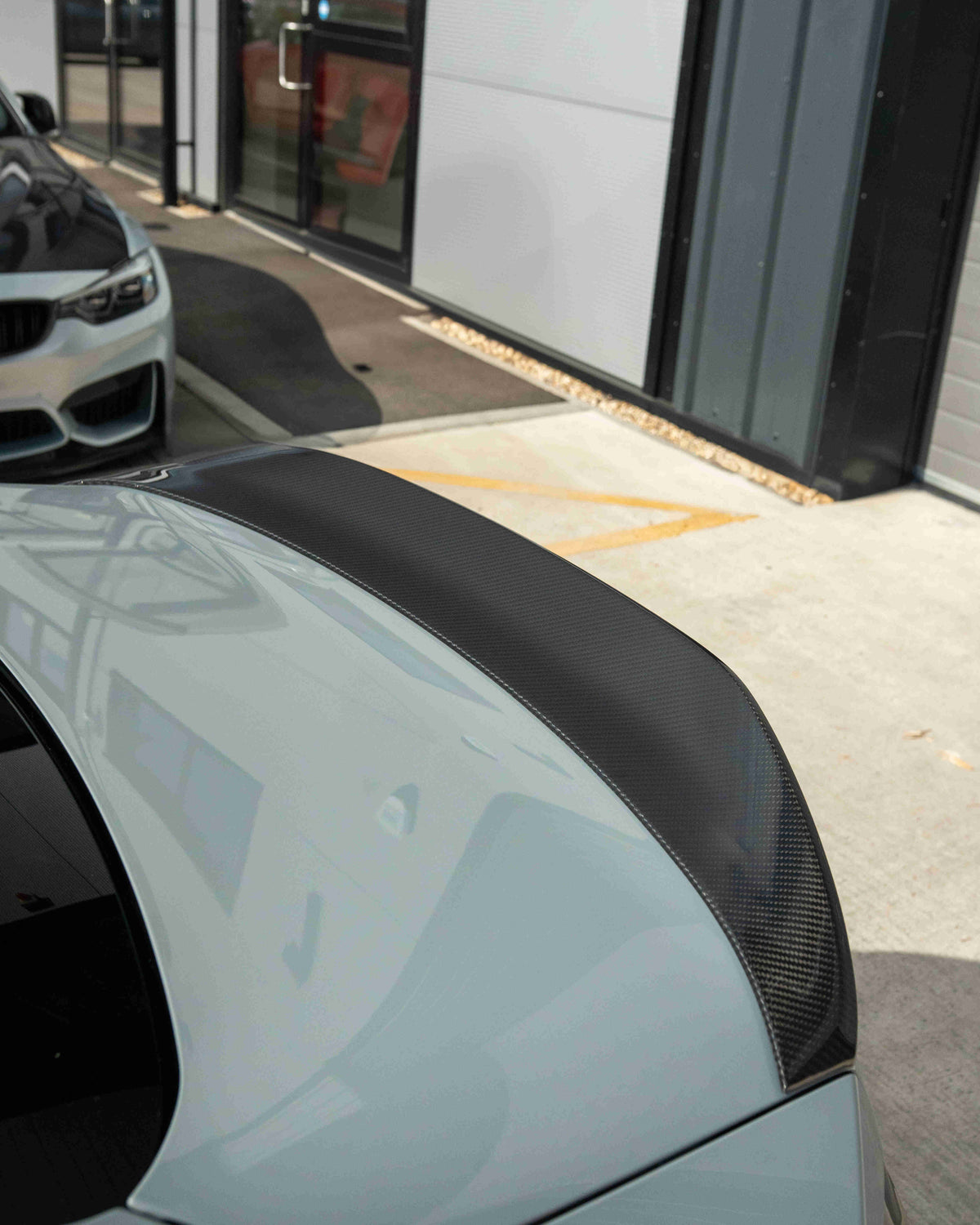 BMW G87 M2 and G42 2 Series carbon fibre spoiler by CT Design, showcasing sleek aerodynamic design on a dark car.
