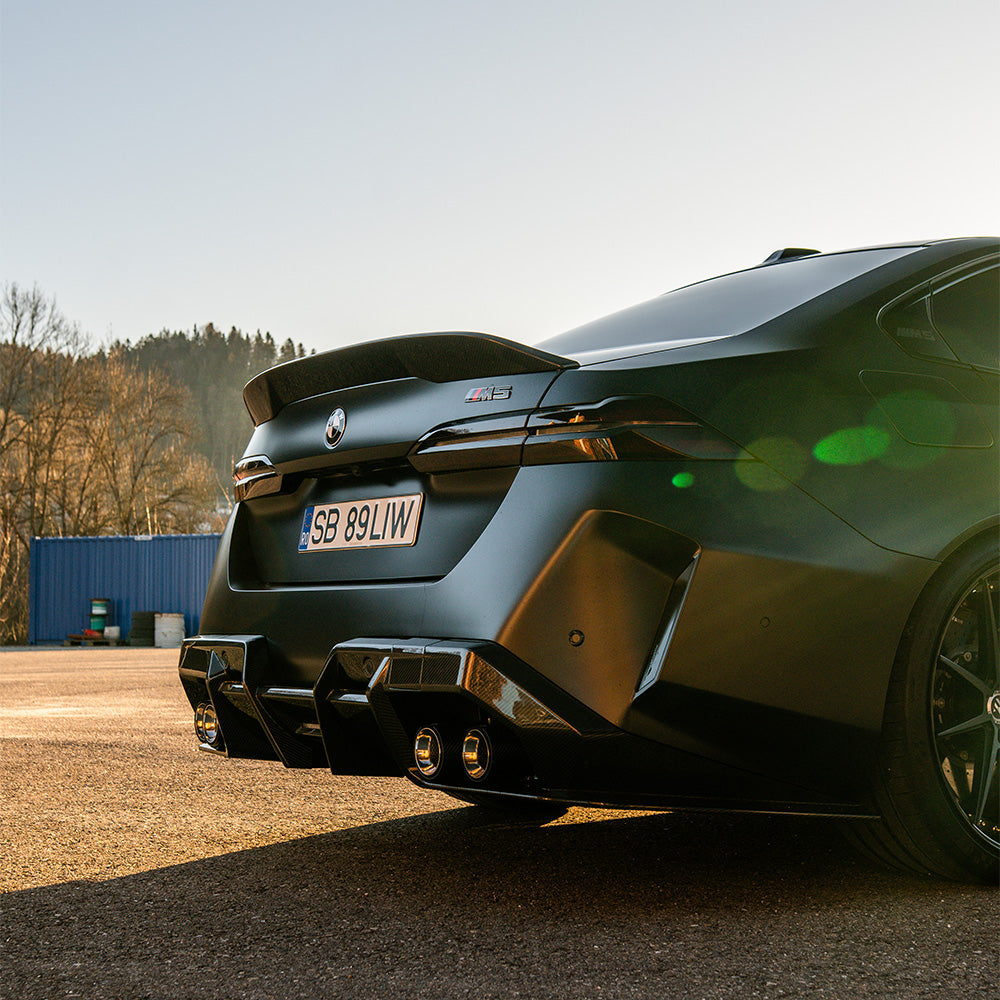 BMW G90 G99 M5 2024 carbon fibre diffuser by CT Design, showing sleek aerodynamic design and textured carbon fibre surface.