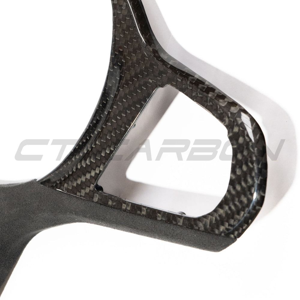 BMW Gxx M carbon fiber steering wheel trim accessory by CT Carbon with heating and accessories, shown on a steering wheel.