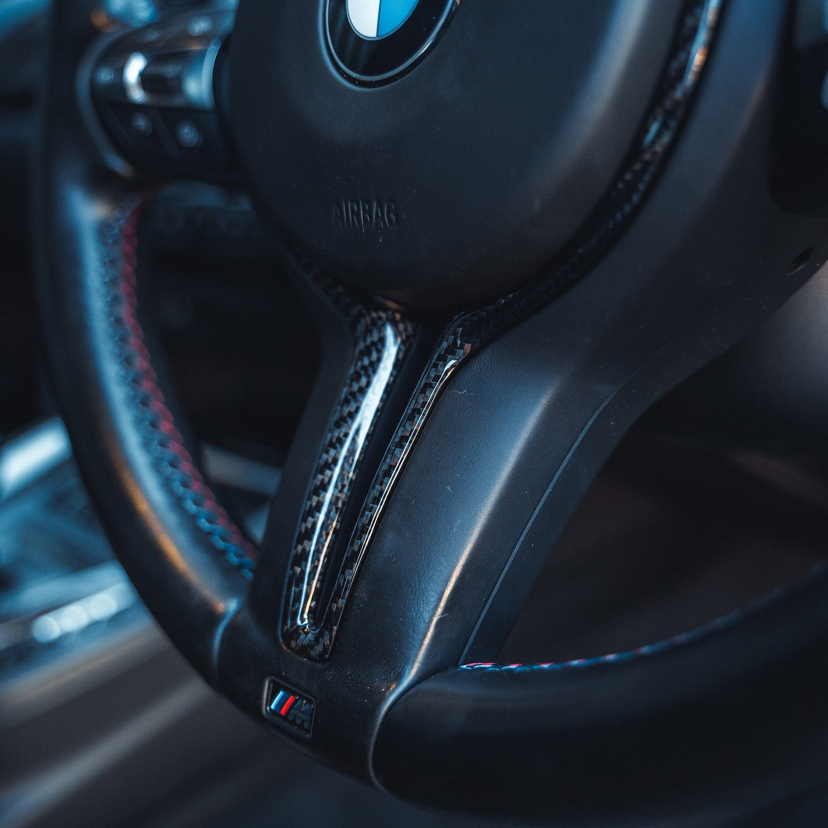 BMW M Fxx carbon fiber steering wheel trim by CT Carbon, designed for 2012-2020 M models, close-up view of sleek interior accessory.