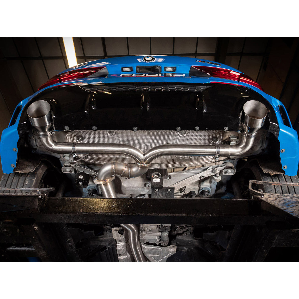 Cobra Sport BMW M135i F40 Venom Cat Back Race Box Delete Performance Exhaust installed on a black BMW M135i F40.