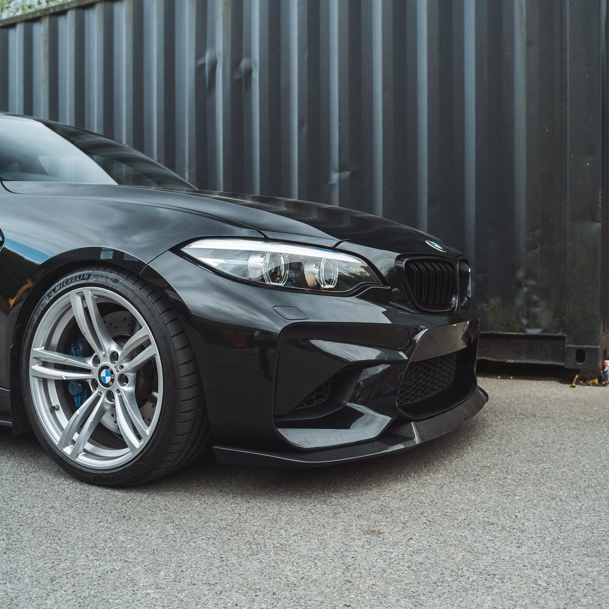 BMW M2 F87 N55 carbon fibre splitter V2 by CT Carbon, showing the sleek, textured carbon fiber design mounted on the front of the car.