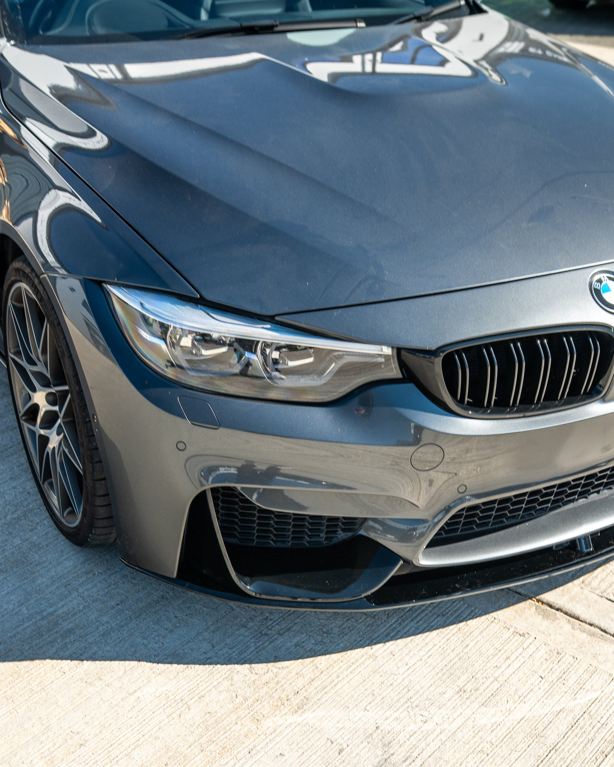 BMW M3 M4 F80 F82 F83 CT Carbon gloss black splitter V1 installed on front lower bumper, enhances sporty appearance.