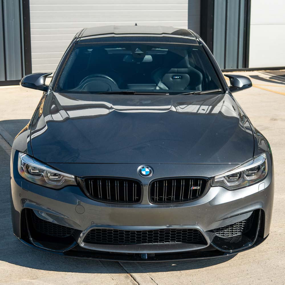 BMW M3 (F80) 2014-2020 CT Carbon full gloss black kit installed on coupe, showcasing sleek exterior upgrade details.