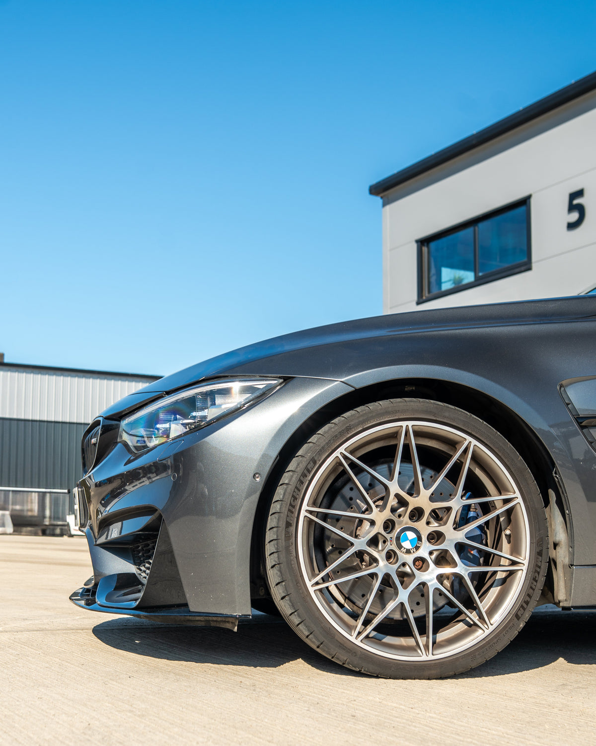 BMW M3 M4 F80 F82 F83 splitters by CT Carbon in gloss black, shown on the front of a coupe vehicle.