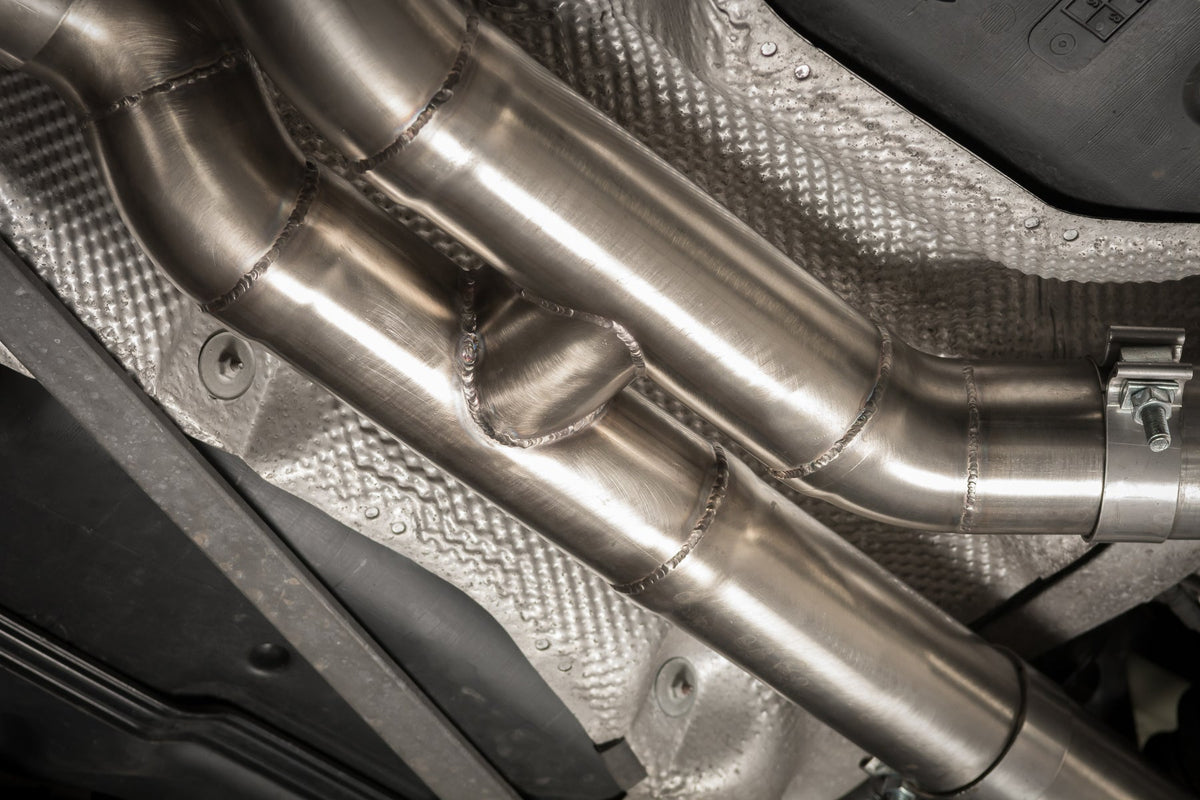 Cobra Sport BMW M3 F80 3-inch valved primary cat back performance exhaust system installed on a white BMW M4 F82.
