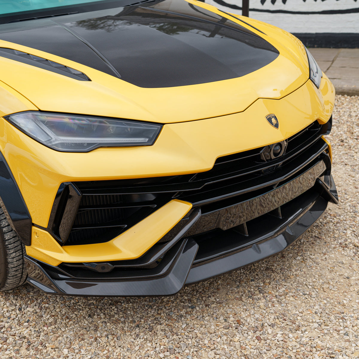 Carbon fiber splitter for Lamborghini Urus Performante by CT Carbon, showcasing sleek, aerodynamic design on a high-performance SUV.