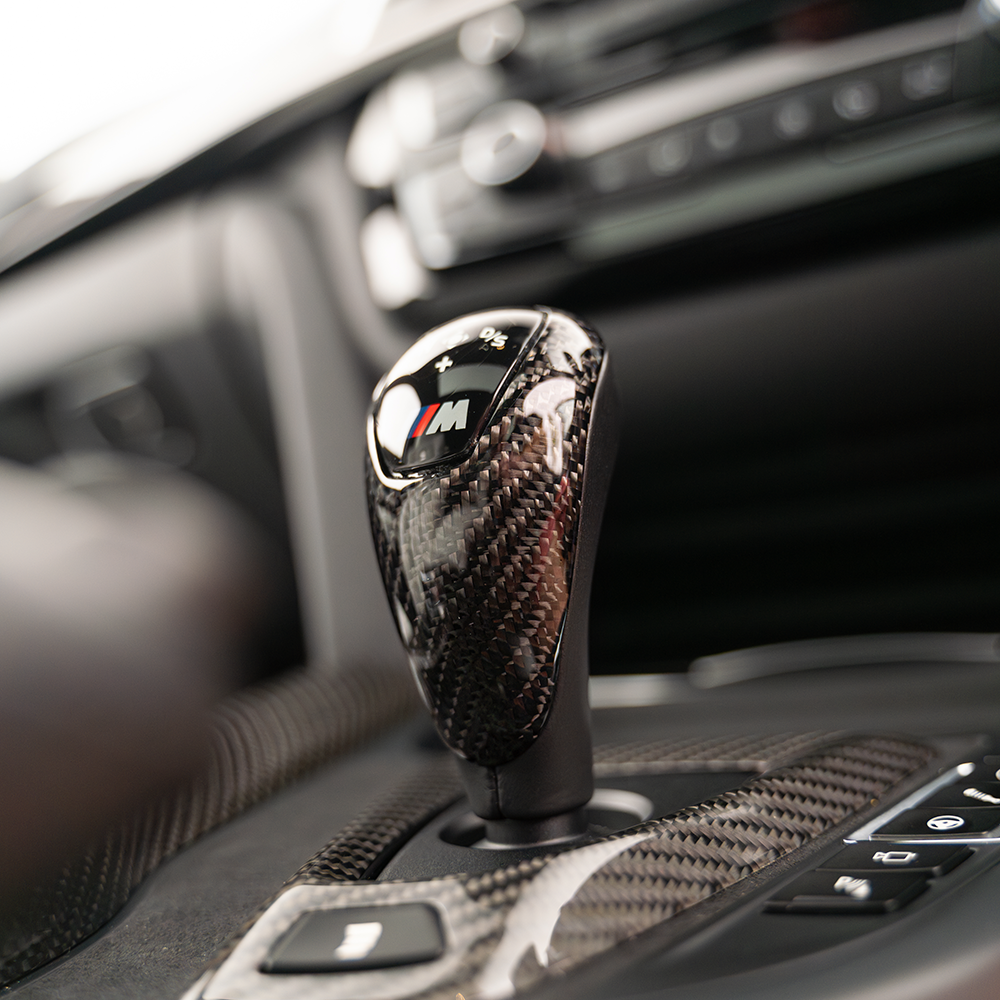 CT Carbon shift knob for BMW M series models including M2, M3, M4, F10, F12, F13, F80, F82, F83, and F87 showing a sleek black design