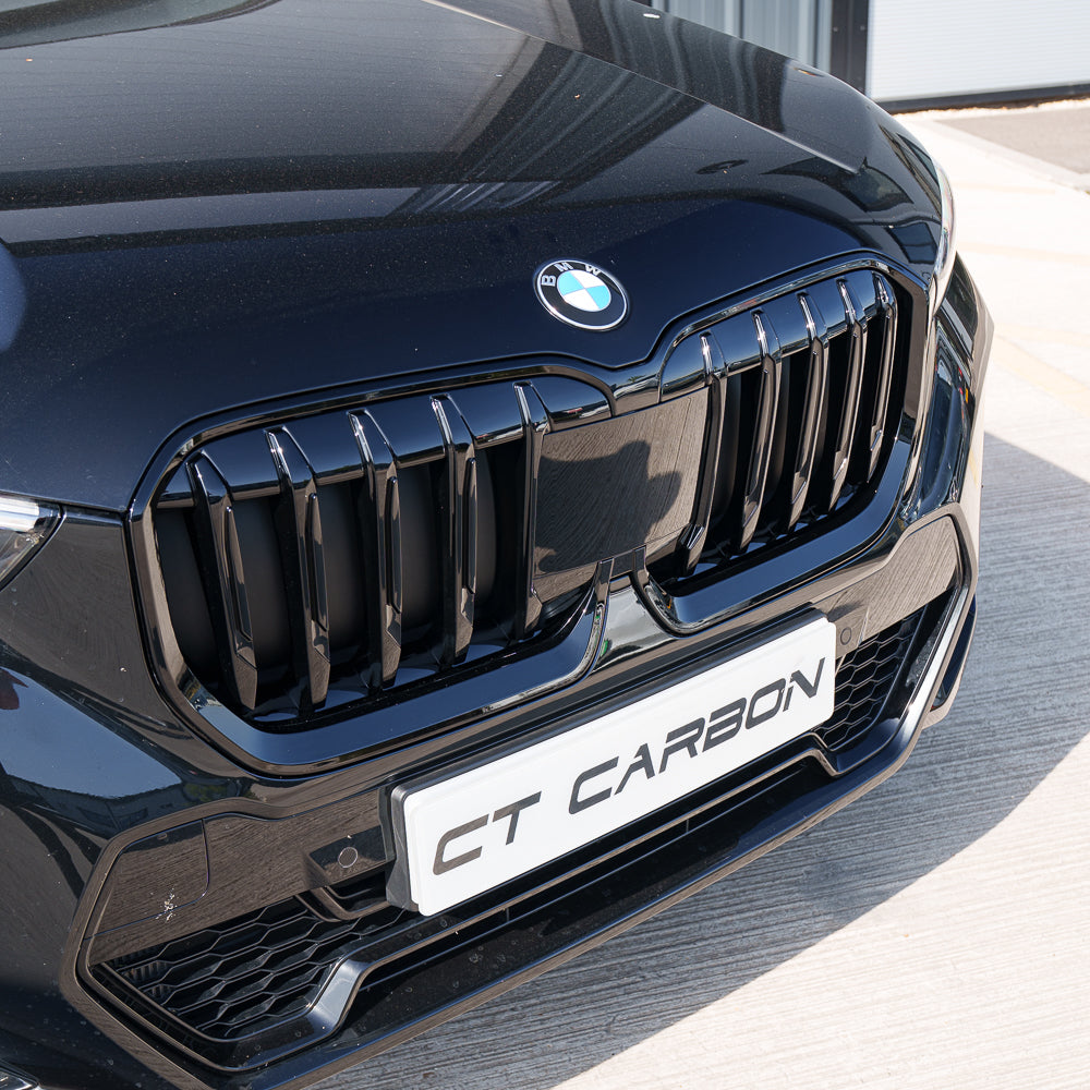 BMW U11 X1 2023 gloss black single slat grille by CT Carbon, close-up view of sleek, high-quality automotive grille.