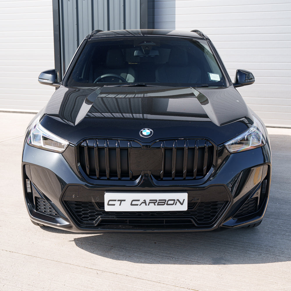 BMW U11 X1 2023 gloss black single slat grille by CT Carbon, close-up view of the sleek, glossy black automotive grille.