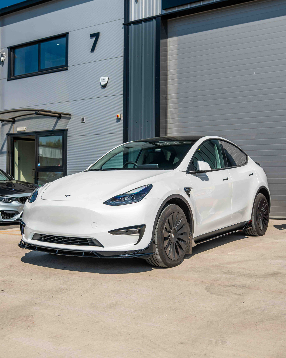 Full gloss black car kit for Tesla Model Y MK1 2020-2025 by CT Carbon, shown on a vehicle with close-up view of the kit components.