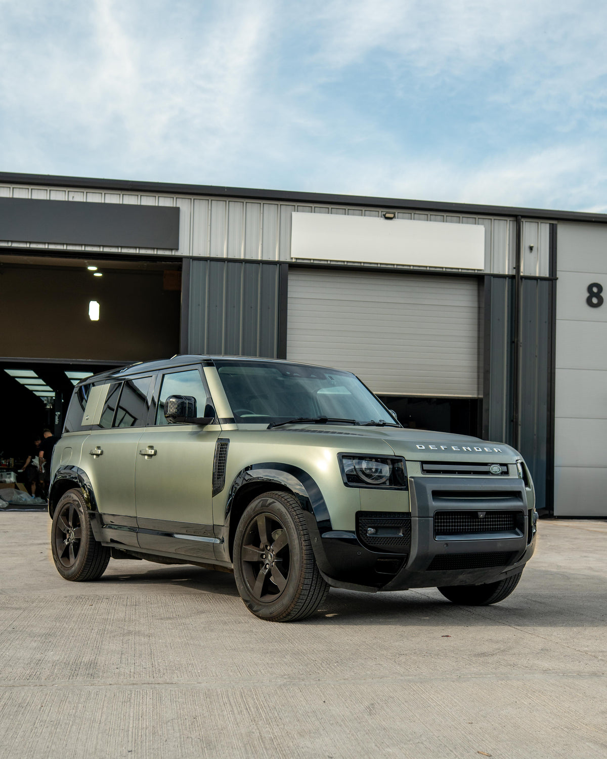 Gloss black door panels for Land Rover Defender L663 110 by CT Carbon, shown in a close-up view of the vehicle's doors.