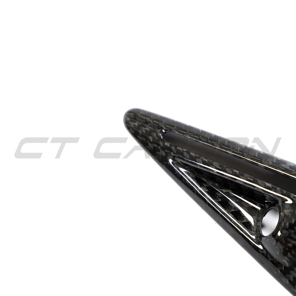 Tesla Model 3 2017-2023 carbon fiber side camera cover by CT Carbon, close-up of sleek, textured automotive accessory.