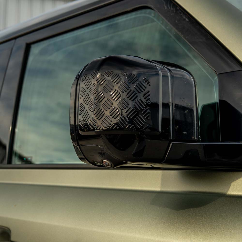 Land Rover Defender L663 110 gloss black anti-scratch trim set by CT Carbon, featuring close-up of sleek, protective vehicle trim pieces.