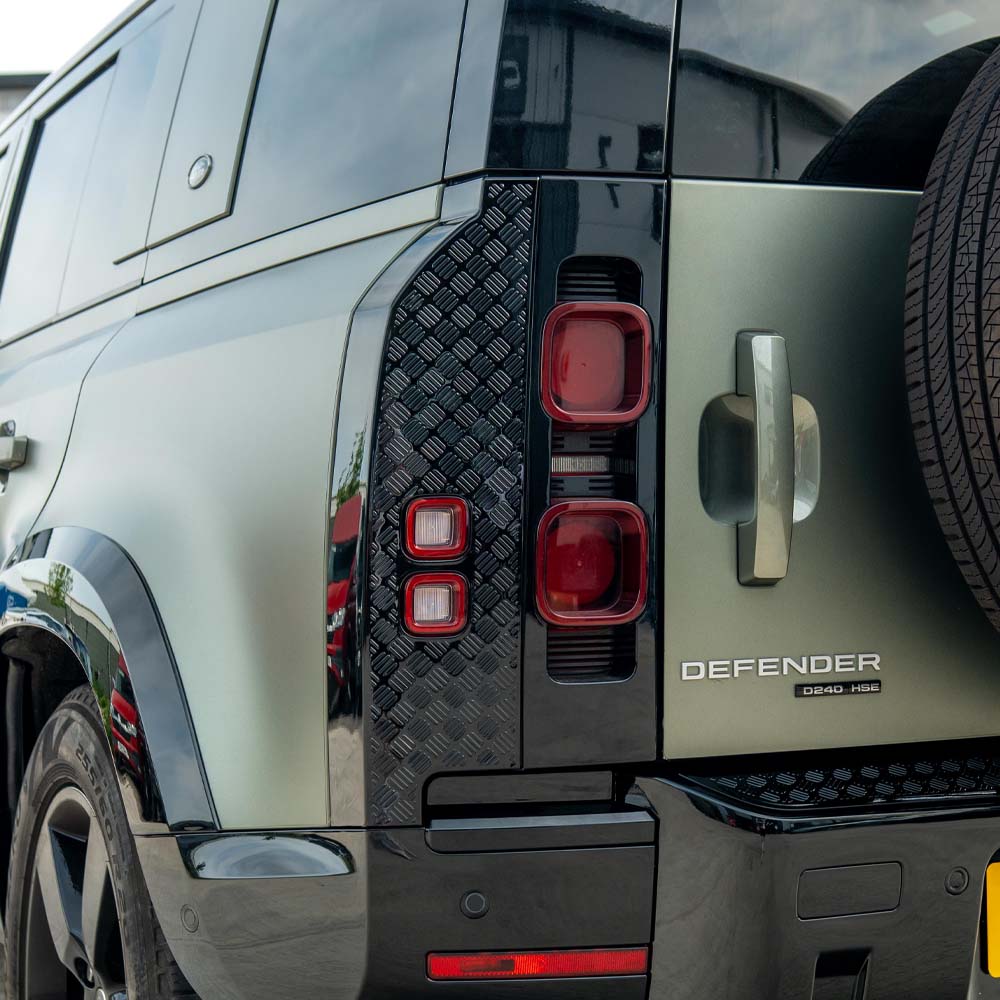 Land Rover Defender L663 110 gloss black anti-scratch trim set by CT Carbon, with close-up of sleek, protective vehicle exterior trim.