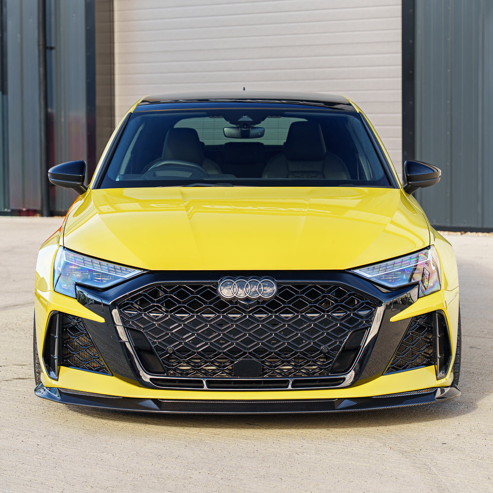 Carbon fiber splitter for Audi RS3 8Y 2025+ by CT Carbon, featuring V2 design, mounted on front bumper, with detailed textured surface.