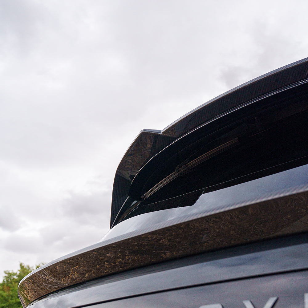 Range Rover L460 2022+ carbon fiber middle spoiler by CT Carbon, close-up of sleek, aerodynamic car accessory on vehicle.