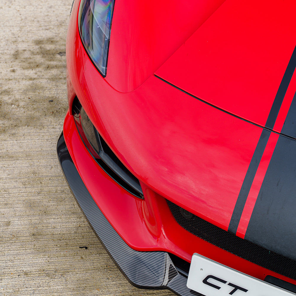 Red Lotus Emira car with CT Carbon front splitter, showcasing a sleek carbon fibre splitte in a detailed view.