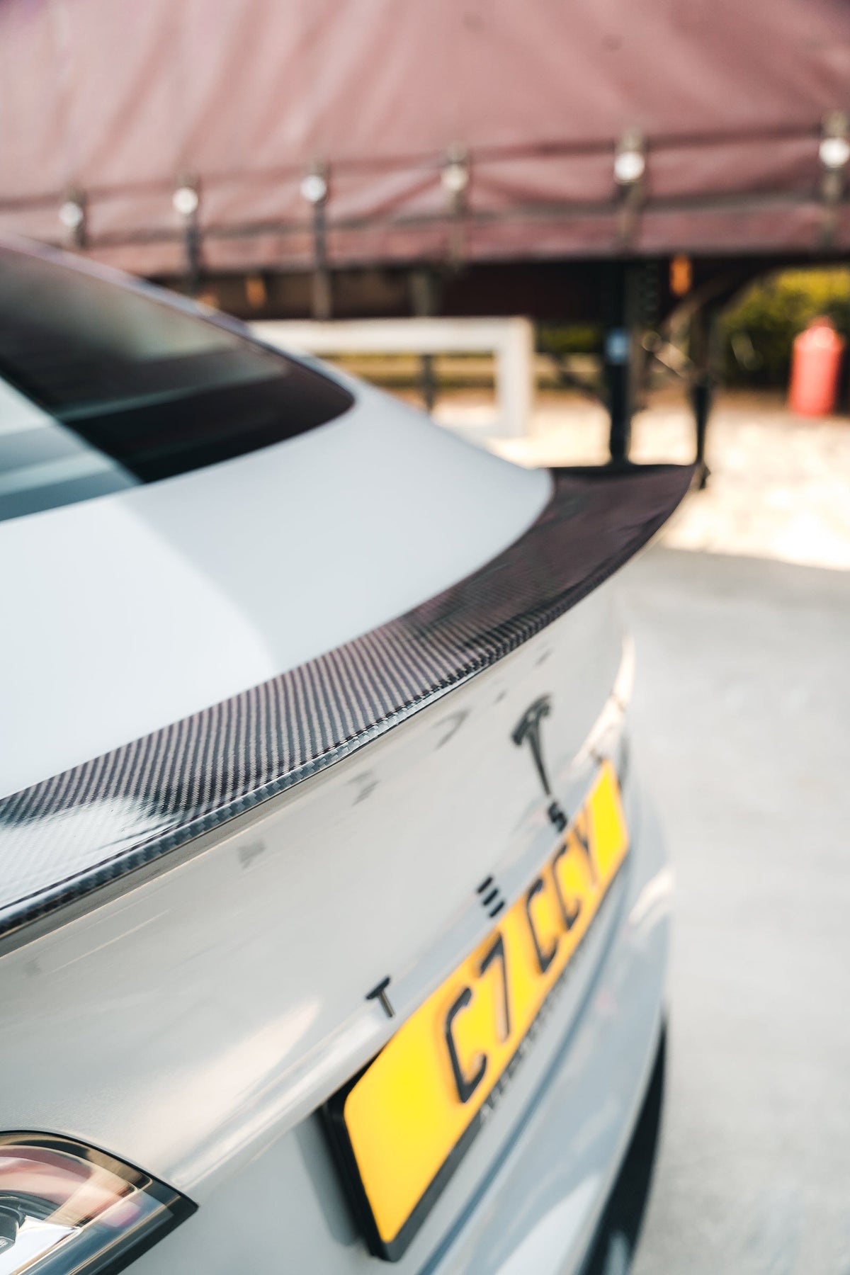 Tesla Model 3 2017-2023 carbon fiber V-style spoiler by CT Carbon, showcasing sleek, lightweight aerodynamic design on the car's rear.