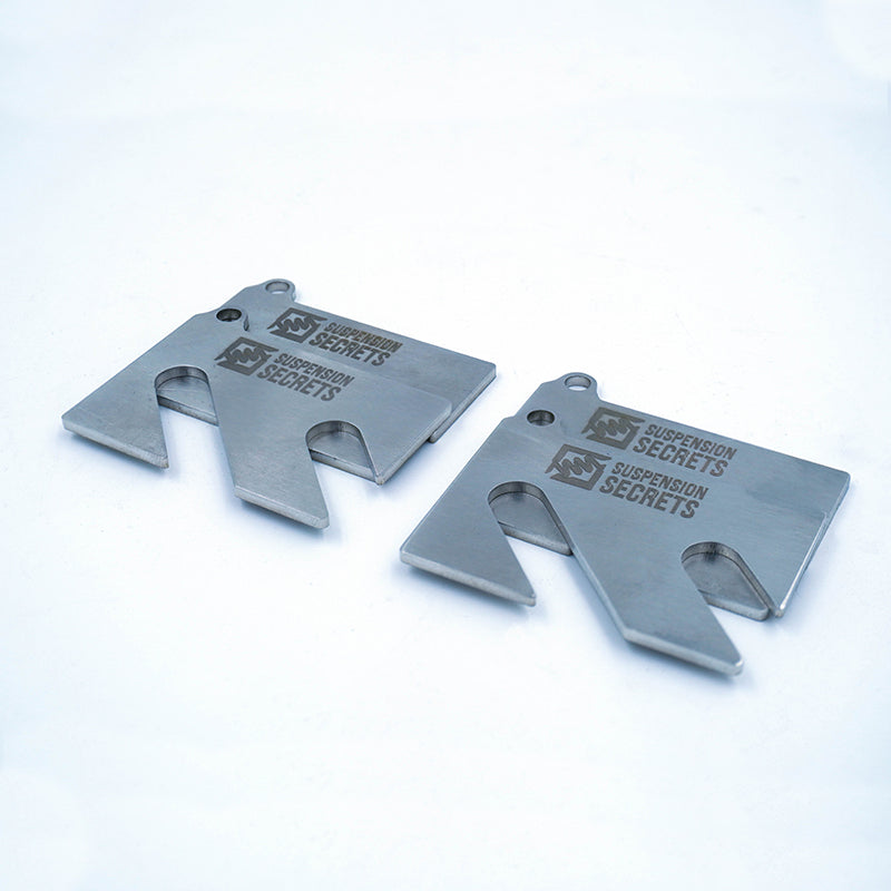 Suspension Secrets front and rear camber shim kit for Porsche 981 and 718 Cayman GT4, showing metal suspension linkages.